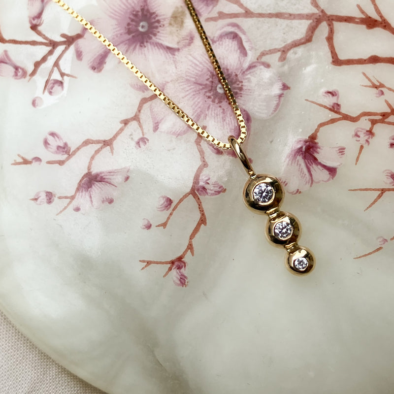 Kuglevedhæng i 14 karat guld med 3 diamanter på i alt 0,06 ct tw/vs