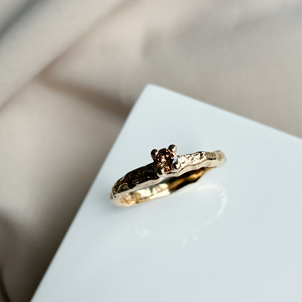 Solitairering i 14 karat guld med en 0,15 ct mørk champagnediamant