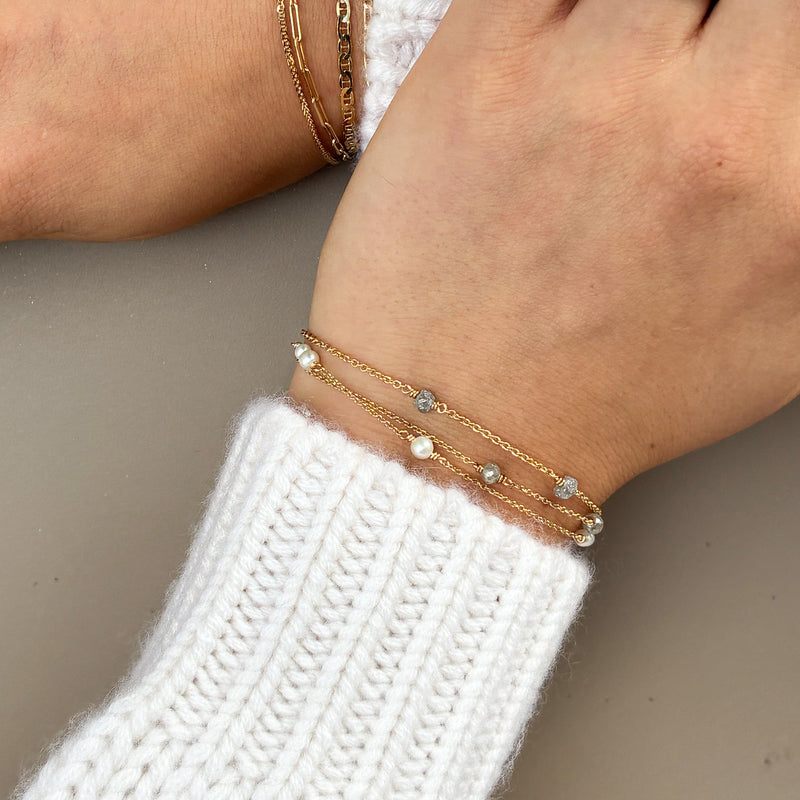 Armbånd i 14 karat guld med tre grå rådiamanter