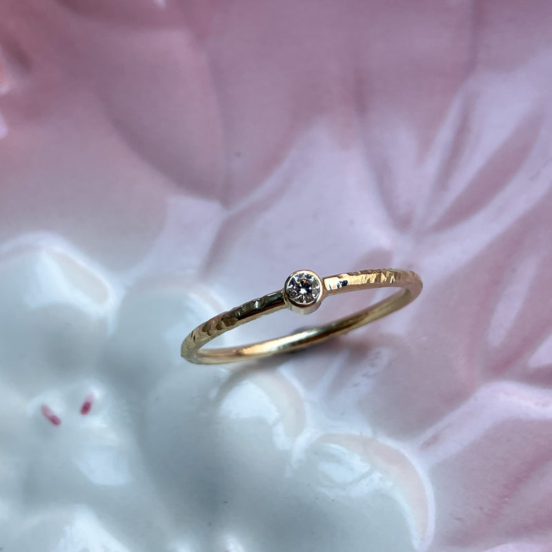 Smuk klassisk ring med rund ringskinne og en rørfatning med en lys champagnefarvet naturlig diamant. Ringen har fået en struktureret overflade, som er håndlavet med filestrøg, og derefter blankpoleret. 