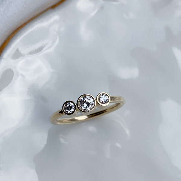 Klassisk 3 stens ring i 14 karat gult guld lavet med smukke enkle rørfatninger med hvide diamanter, og en rund ringskinne i blankpoleret guld. Klassisk forlovelsesring