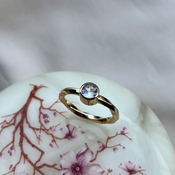 Twisted ring I 14 karat guld med en hvid safir på 0,45 ct. i rørfatning