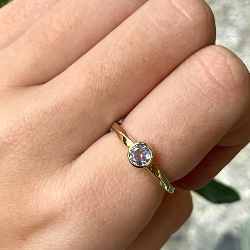 Twisted ring I 14 karat guld med en hvid safir på 0,45 ct. i rørfatning