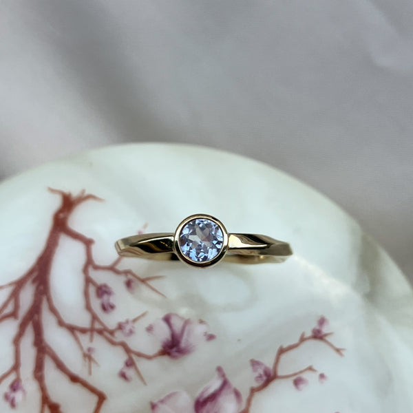 Twisted ring I 14 karat guld med en hvid safir på 0,45 ct. i rørfatning