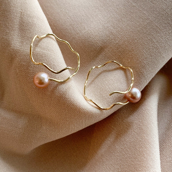 Spiraløreringe i 14 karat guld med lyserøde perler
